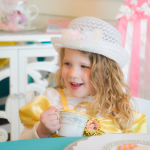 Little girl sipping tea with friends at a tea party